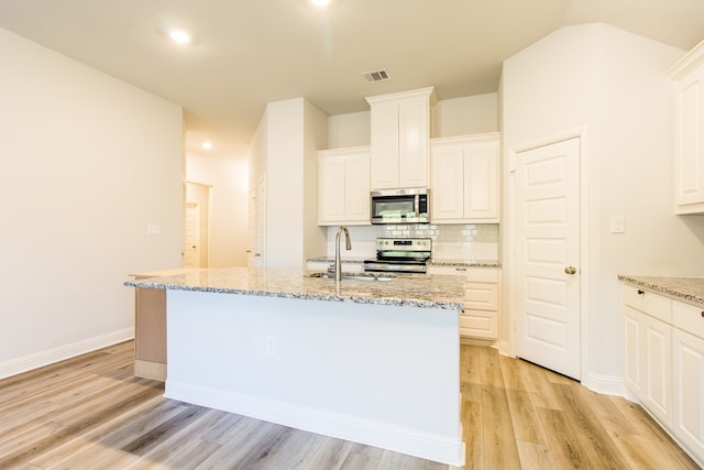 kitchen with a center island with sink, appliances with stainless steel finishes, and sink