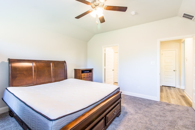 bedroom with light hardwood / wood-style floors, lofted ceiling, ceiling fan, and ensuite bathroom