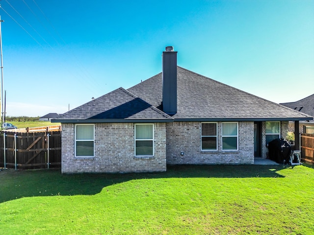 rear view of house featuring a yard