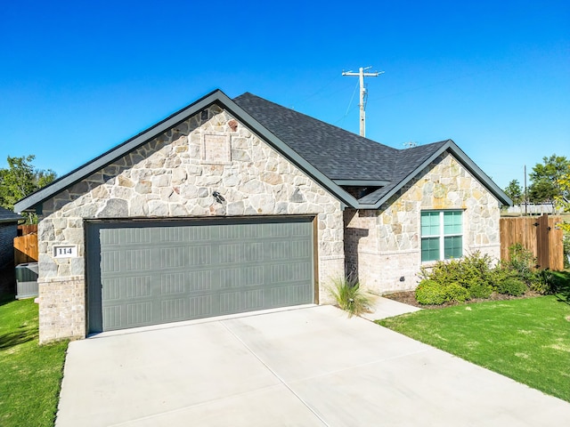 view of front of house featuring a garage and a front lawn