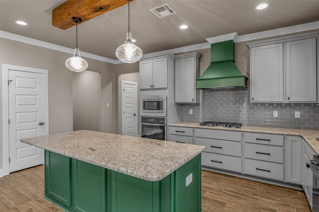 kitchen with stainless steel appliances, a center island, light wood-type flooring, and custom range hood