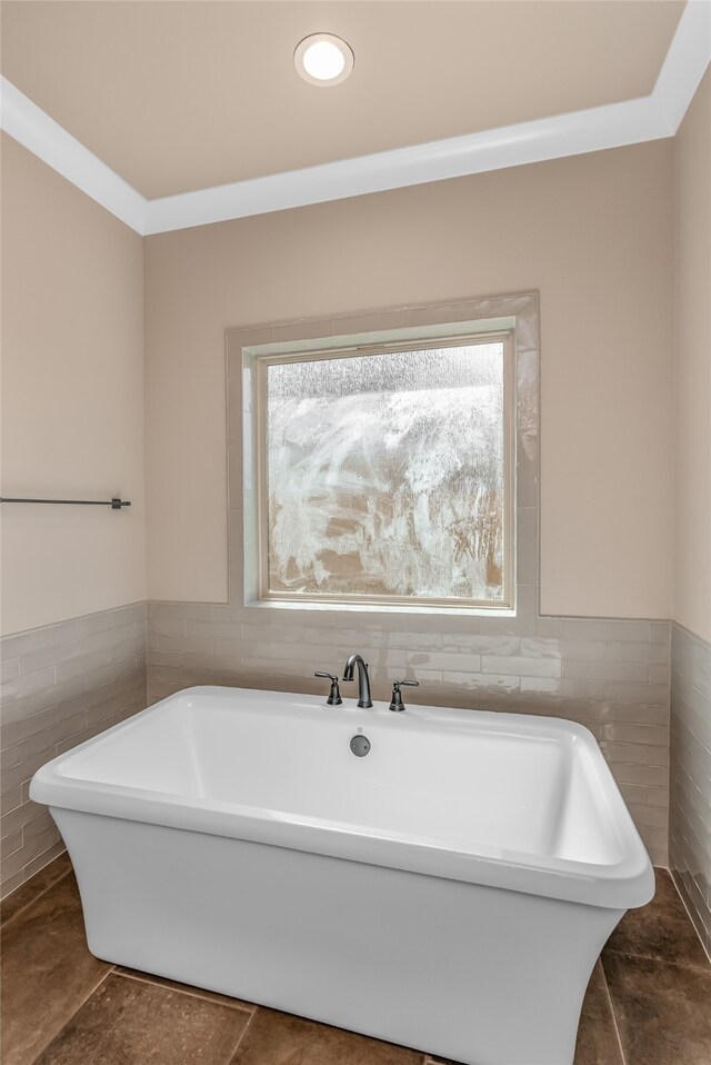 bathroom with a healthy amount of sunlight, tile walls, and a washtub