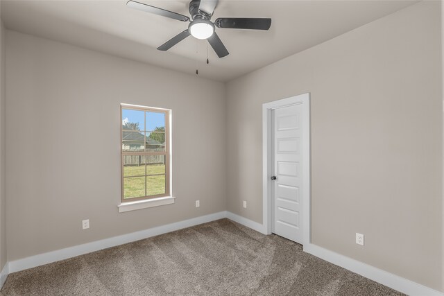 carpeted spare room featuring ceiling fan