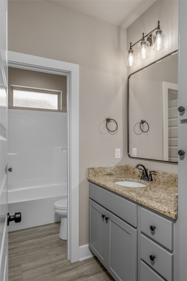 bathroom with wood-type flooring, vanity, and toilet