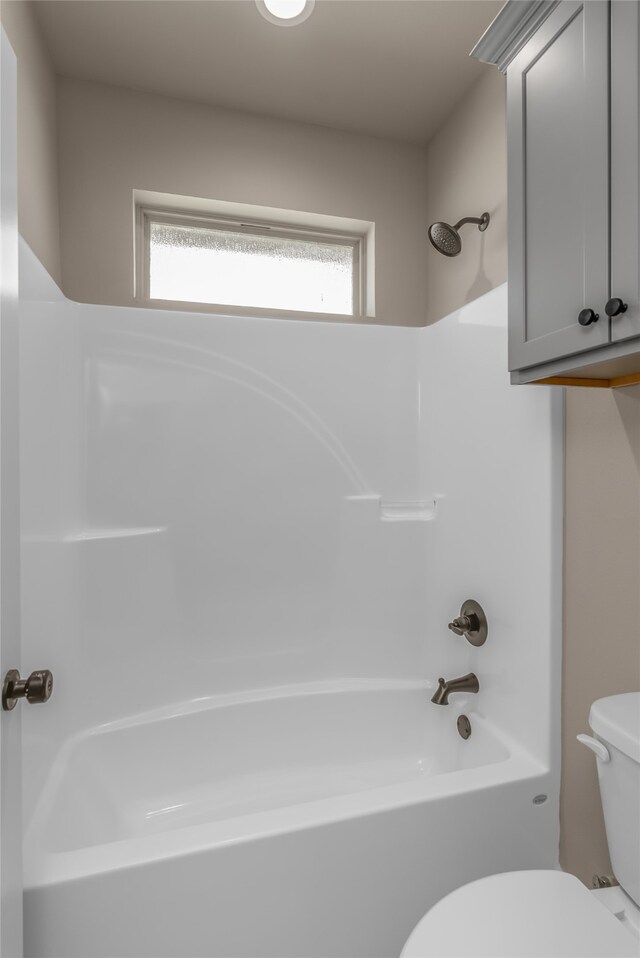 bathroom featuring shower / bath combination and toilet