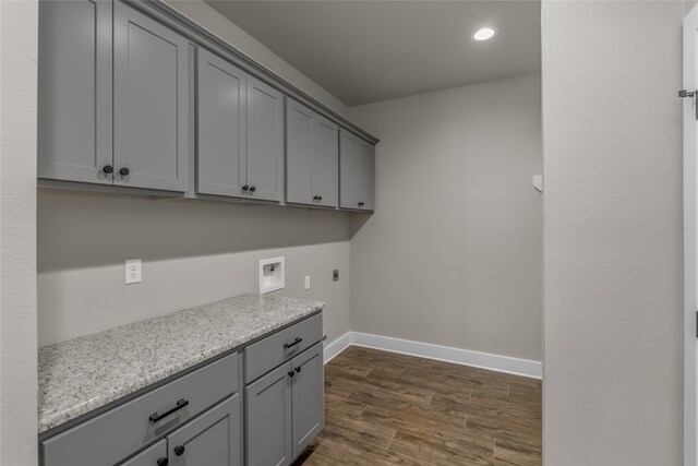 clothes washing area featuring washer hookup, hookup for an electric dryer, dark wood-type flooring, and cabinets