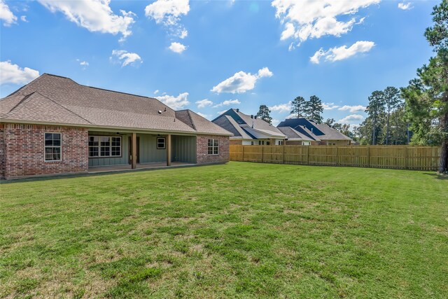 rear view of property featuring a yard and a patio