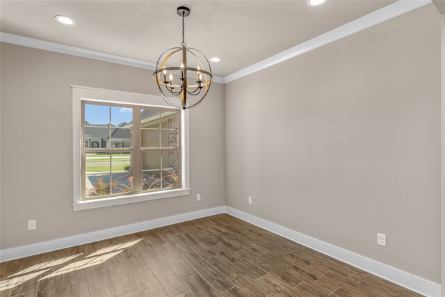 unfurnished dining area featuring a notable chandelier, ornamental molding, and dark hardwood / wood-style flooring