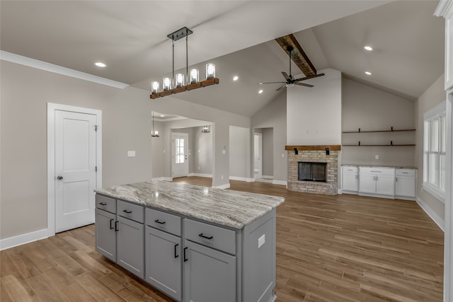 kitchen with a center island, pendant lighting, ceiling fan, and light hardwood / wood-style flooring