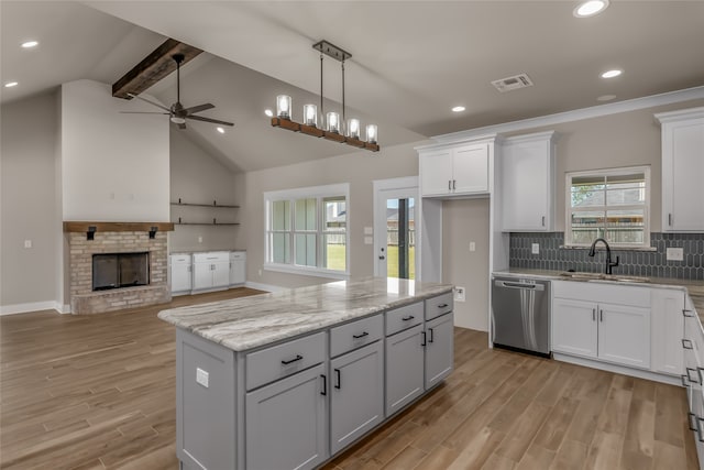 kitchen with stainless steel dishwasher, sink, and white cabinets