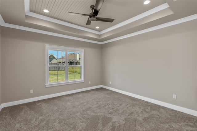 unfurnished room featuring ceiling fan, a raised ceiling, carpet flooring, and crown molding