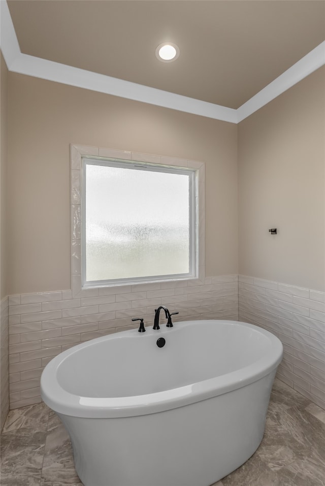 bathroom with a bathtub, tile walls, and a wealth of natural light