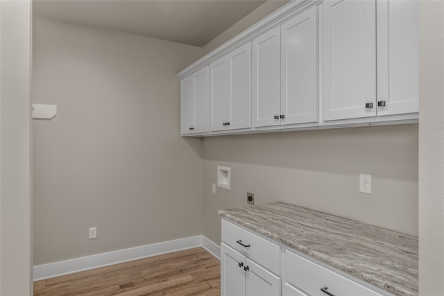 laundry area featuring hookup for a washing machine, light hardwood / wood-style floors, electric dryer hookup, and cabinets