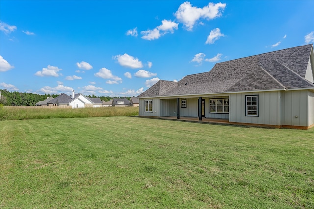 rear view of house featuring a lawn