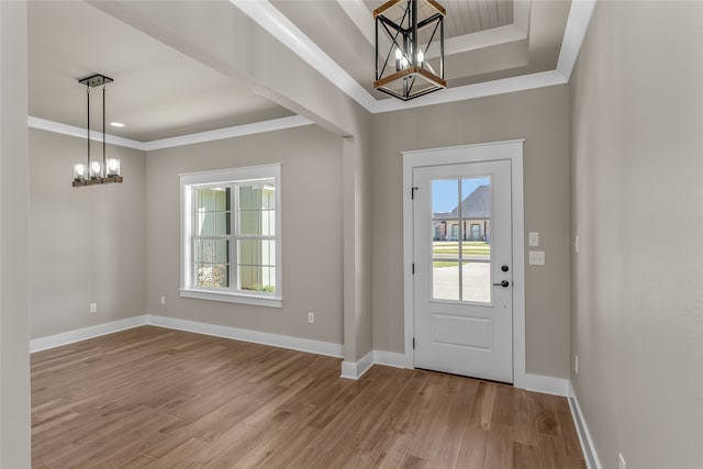 foyer with light hardwood / wood-style flooring, crown molding, and a healthy amount of sunlight