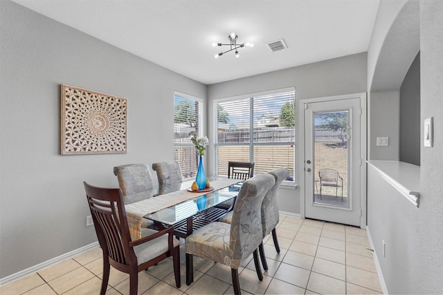 tiled dining room with a notable chandelier