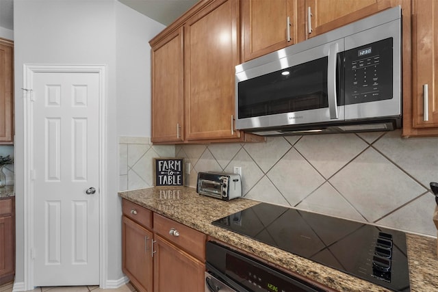 kitchen with black appliances, stone countertops, and backsplash