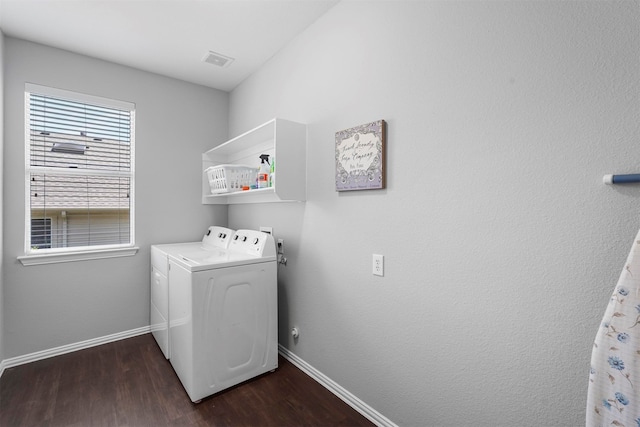 clothes washing area with dark hardwood / wood-style floors and washer and clothes dryer