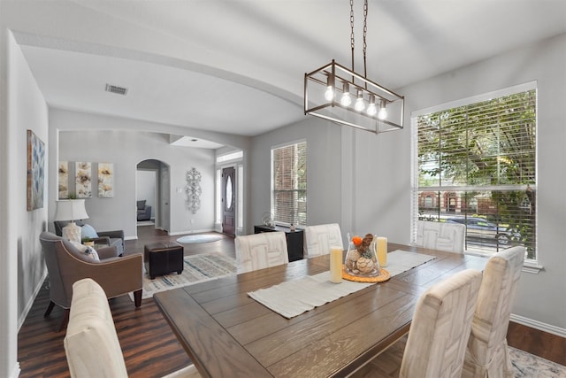 dining room featuring a chandelier, dark wood-type flooring, and a wealth of natural light