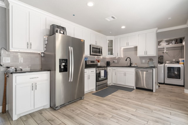 kitchen featuring ornamental molding, light hardwood / wood-style floors, white cabinetry, and stainless steel appliances