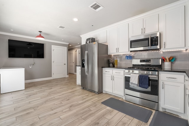 kitchen with white cabinets, appliances with stainless steel finishes, light wood-type flooring, and crown molding