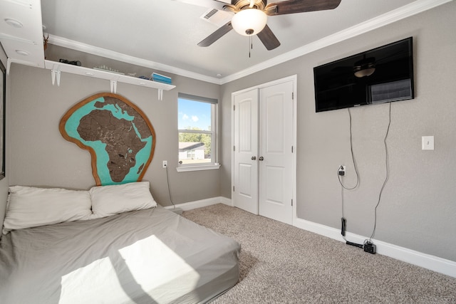 carpeted bedroom featuring ornamental molding, a closet, and ceiling fan