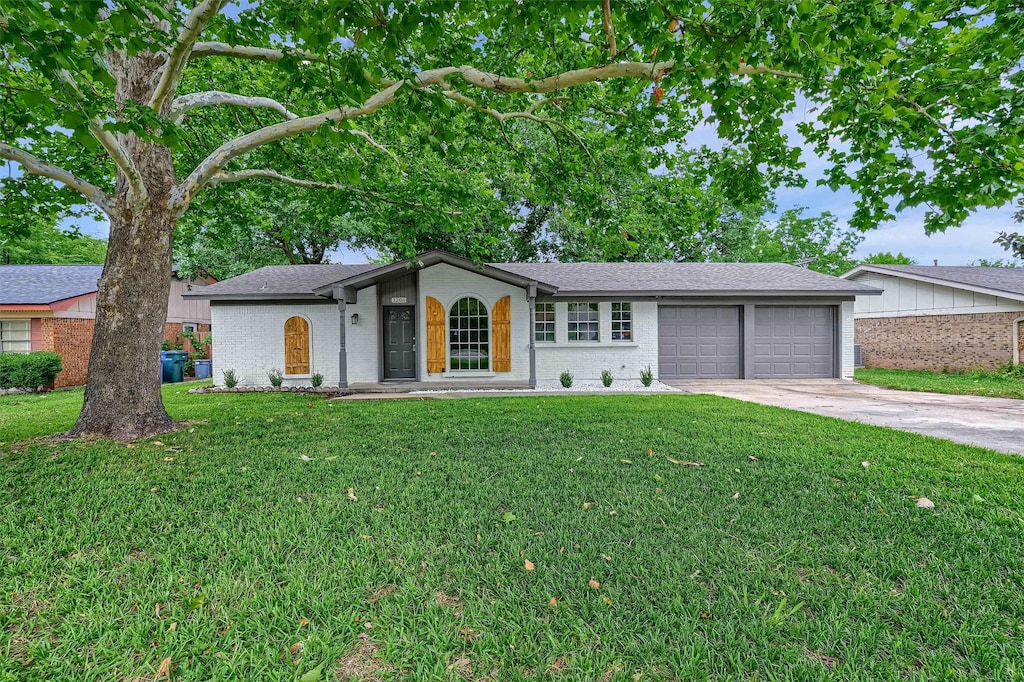 single story home featuring a front yard and a garage