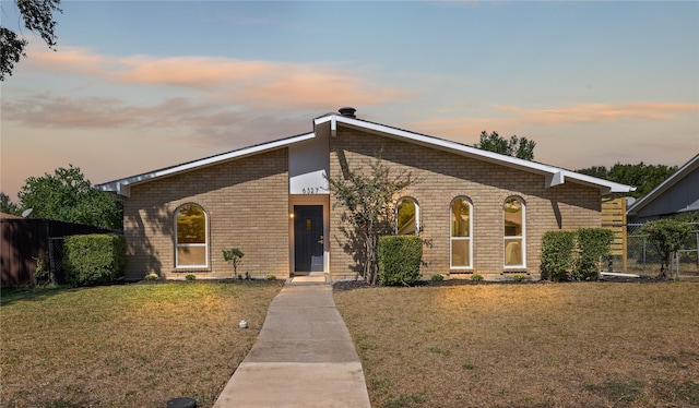 single story home featuring a lawn