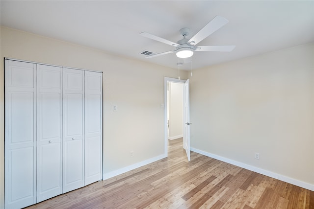 unfurnished bedroom with ceiling fan, a closet, and light wood-type flooring