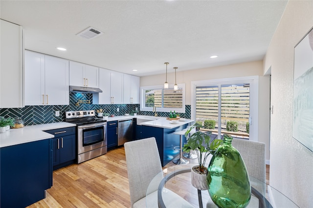 kitchen featuring blue cabinetry, appliances with stainless steel finishes, white cabinetry, hanging light fixtures, and light wood-type flooring