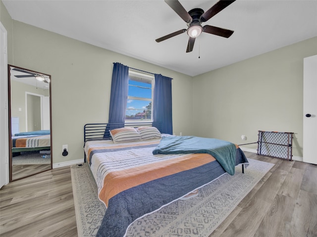 bedroom with light hardwood / wood-style floors and ceiling fan