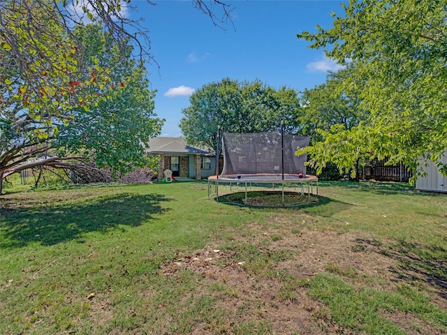 view of yard featuring a trampoline and a storage shed