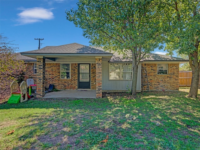 rear view of property featuring a yard and a patio area