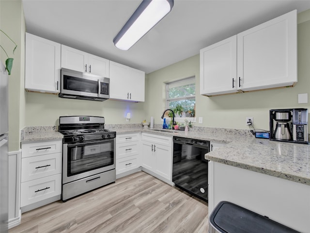 kitchen with sink, light hardwood / wood-style flooring, stainless steel appliances, and white cabinets