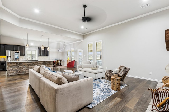 living room with ceiling fan, dark hardwood / wood-style floors, and ornamental molding