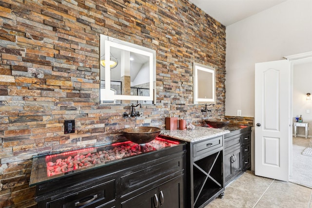 kitchen featuring light stone counters, sink, and light tile patterned floors