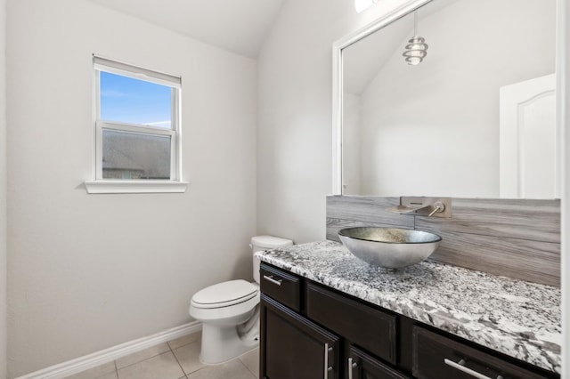 bathroom with tile patterned floors, vanity, toilet, and lofted ceiling