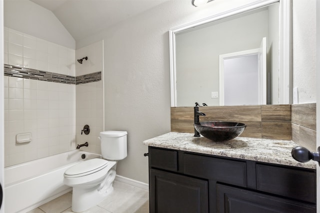 full bathroom with vanity, tile patterned floors, vaulted ceiling, tiled shower / bath combo, and toilet