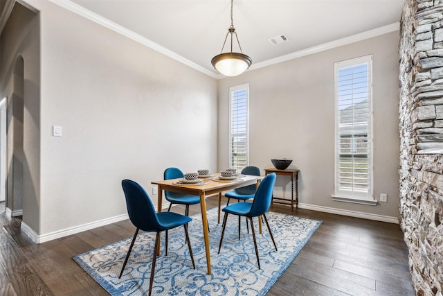 dining space featuring ornamental molding and dark wood-type flooring