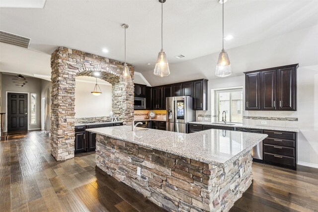 kitchen featuring decorative light fixtures, a spacious island, and appliances with stainless steel finishes