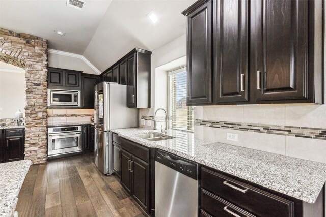 kitchen featuring lofted ceiling, sink, decorative backsplash, dark hardwood / wood-style flooring, and stainless steel appliances