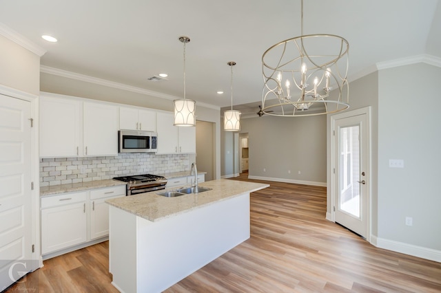 kitchen with pendant lighting, a center island with sink, white cabinets, sink, and stainless steel appliances