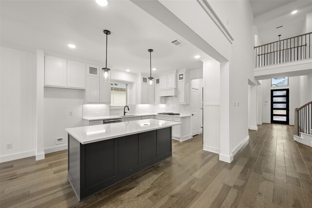 kitchen featuring a center island, plenty of natural light, dark wood-type flooring, and sink