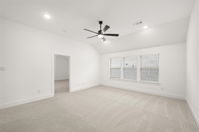 unfurnished room with ceiling fan, light colored carpet, and vaulted ceiling