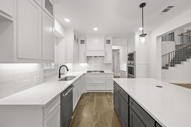 1406 Chickadee Dr, Mansfield, TX 76063 - kitchen featuring appliances with stainless steel finishes, white cabinets, light countertops, wood finished floors, and recessed lighting