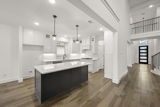 1406 Chickadee Dr, Mansfield, TX 76063 - kitchen with gas cooktop, white cabinets, glass insert cabinets, light countertops, and dark wood-style flooring
