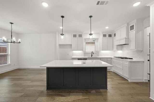 1406 Chickadee Dr, Mansfield, TX 76063 - kitchen with stainless steel gas stovetop, wood finished floors, a center island, tasteful backsplash, and recessed lighting