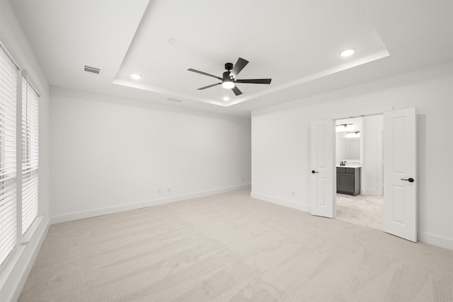 1406 Chickadee Dr, Mansfield, TX 76063 - unfurnished bedroom featuring a tray ceiling, light carpet, recessed lighting, ensuite bathroom, and ceiling fan