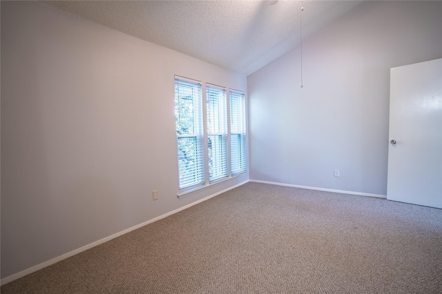 carpeted spare room featuring a textured ceiling and vaulted ceiling