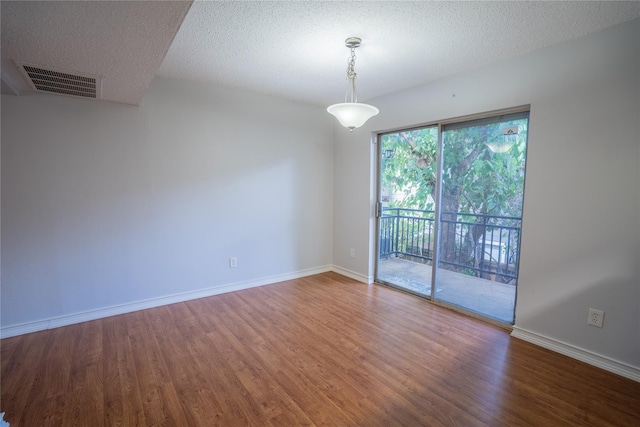 spare room with wood-type flooring and a textured ceiling